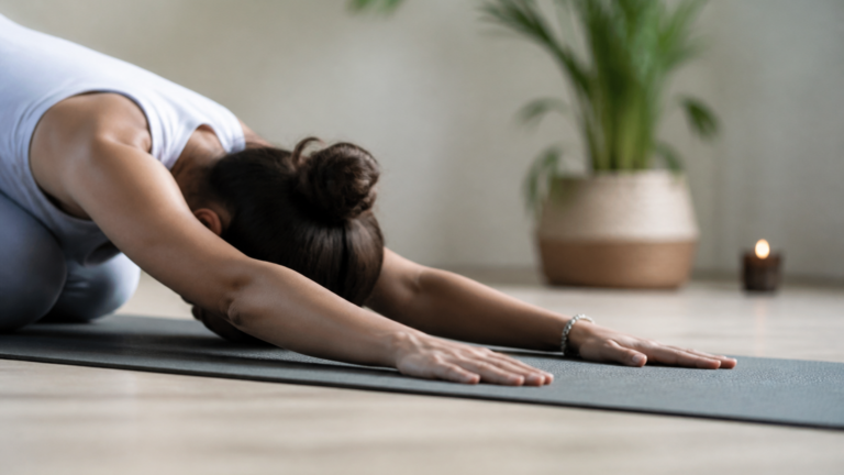 Intérieur calme avec lumière douce, mains posées sur un tapis de yoga, ambiance apaisante et naturelle