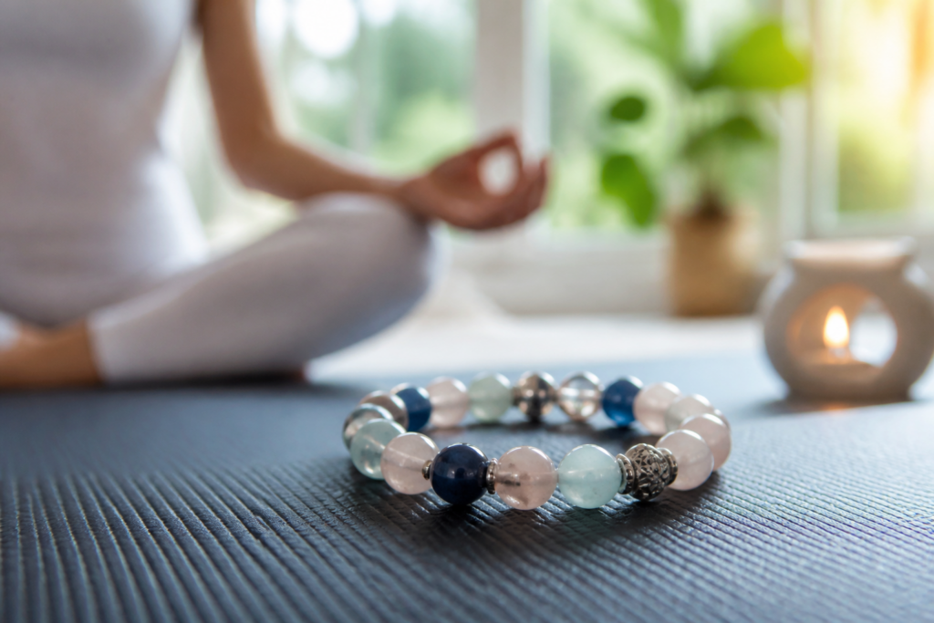 Bracelet en pierres naturelles sur tapis de yoga, symbolisant la confiance en soi et le magnétisme émotionnel.